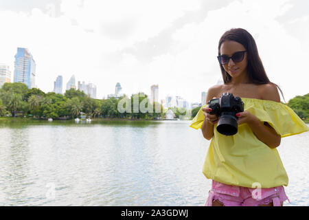 Jeune femme à l'aide d'appareil photo en Thaïlande Bangkok Banque D'Images