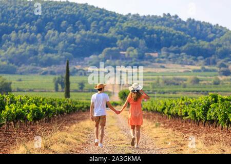 La France, Var, La Motte, à pied d'un jeune couple dans un vignoble Domaine des Vins de Provence Banque D'Images