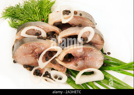 Poissons harengs salés avec oignons, herbes, épices sur un fond blanc Banque D'Images