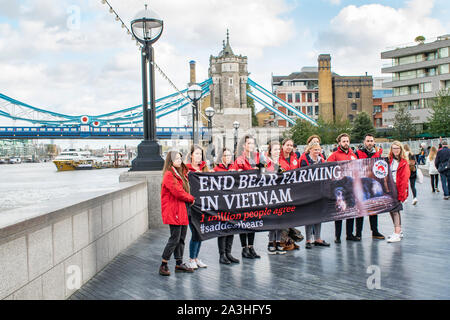 Fin de l'agriculture de l'ours au Vietnam manifestants faisant une séance photo avec bannière par le Tower Bridge et la Tamise, Londres Banque D'Images