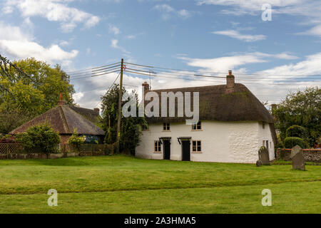 Un cottage blanc laitmé dans le domaine de l'église St James, Avebury, Wiltshire, Angleterre, Royaume-Uni Banque D'Images