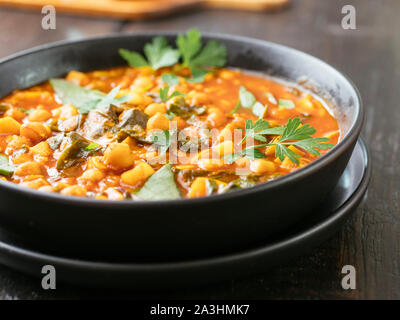 Bol avec une tomate et pois chiche Soupe avec épinards de Malabar. Banque D'Images