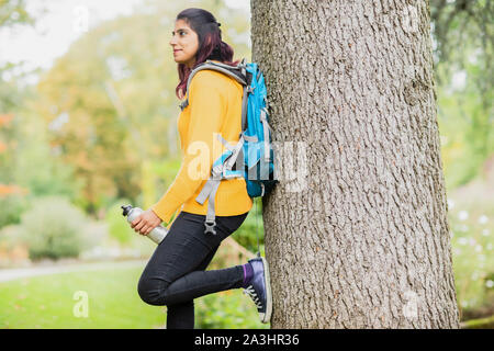 Jeune femme debout près de randonnée et un arbre Banque D'Images