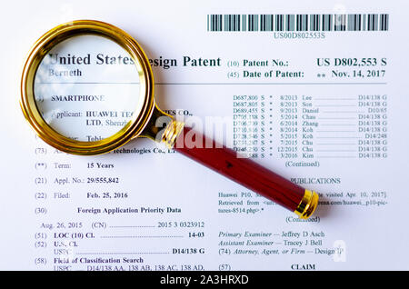 Le gros plan photo de Huawei brevet américain et loupe. Technologies chinois sont sous enquête. Banque D'Images