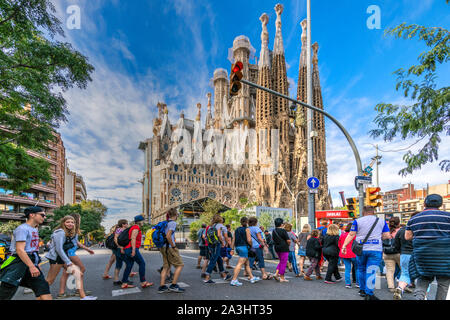 Touristes traversant la rue pour aller visiter la basilique de la Sagrada Familia, église de Barcelone, Catalogne, Espagne Banque D'Images