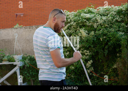 Homme qui fume un narguilé sur fond de vacances concept de vie. L'homme fume un narguilé.Un homme avec une barbe rouge est au repos dans la nature en été. week-end avec Banque D'Images