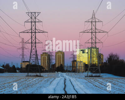 Les lignes électriques et les bâtiments éclairés par le coucher du soleil près de North York en hiver. Banque D'Images