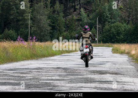 Une femme sur une moto en son ciel nuageux jour d'été.