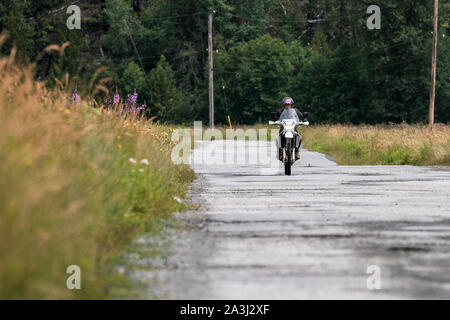 Une femme sur une moto en son ciel nuageux jour d'été.