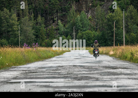 Une femme sur une moto en son ciel nuageux jour d'été.