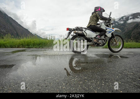 Une femme sur une moto en son ciel nuageux jour d'été.