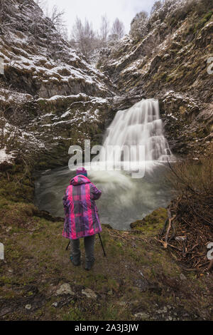 Femme photographiant la cascade dans le Parc National de Somiedo Banque D'Images