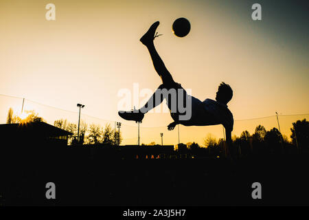 Joueur de foot fait un overhead Kick acrobatique Banque D'Images