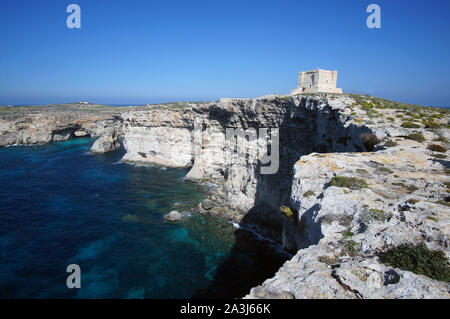 Blue Lagoon avec hautes falaises et Santa Marija Tower sur rumeurs Round Up Island à Malte (Torri ta' Kemmuna) Banque D'Images