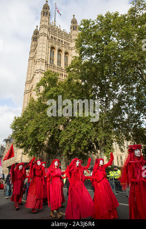 Londres, Royaume-Uni. 05Th Oct, 2019. La troupe d'art performance écologiste rebelles rouges 'Brigade' marche silencieusement près de parlement au cours de la protestation de l'extinction par la rébellion de groupe d'activiste.Extinction La rébellion est un mouvement international qui utilise la désobéissance civile non violente dans une tentative de mettre un terme à l'extinction de masse et de réduire au minimum le risque de l'effondrement social. Le groupe a bloqué un certain nombre de jonctions dans le centre de Londres. Credit : SOPA/Alamy Images Limited Live News Banque D'Images