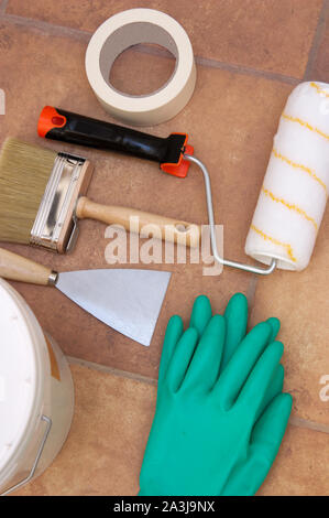 Vue de dessus de certains outils utiles pour peindre les murs d'une maison. Mise à plat des Pinceaux, peinture, spatule, bande bodybuilder, gants, . Banque D'Images