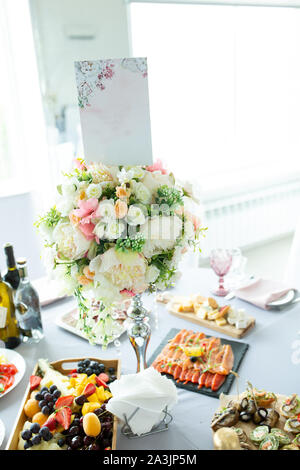 Décorations de table faite de bouquets de fleurs artificielles dans un vase pendant la restauration à l'occasion d'un mariage ou d'événements. Banque D'Images