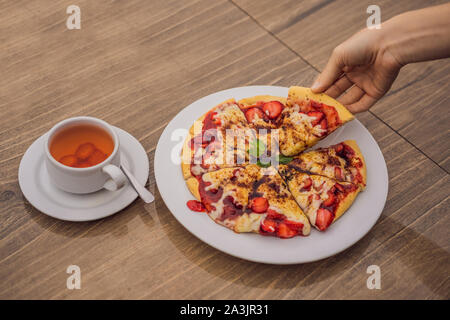 Woman eating pizza aux fraises délicieux sur un fond nature tropical balinais. L'île de Bali, Indonésie Banque D'Images