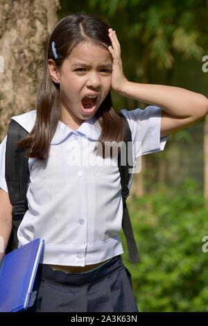 Asian Girl Student sous stress en uniforme avec des livres Banque D'Images