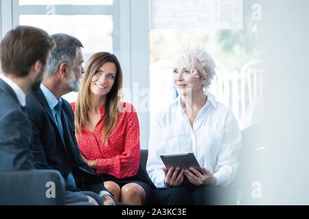 Équipe de professionnels ayant une discussion occasionnels en fonction. Les cadres supérieurs ayant friendly discussion pendant les pauses. Banque D'Images