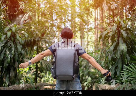 La liberté traveler hommes debout avec les bras levés et bénéficiant d'une très belle nature et encourager les jeunes au coucher du soleil, vous détendre en vacances le temps de voyage concept Banque D'Images