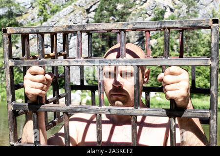 L'homme en prison ou la prison. Les hommes dans une cage à l'extérieur. danger ou d'agression concept Banque D'Images