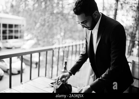 Bien habillé beau homme arabe à cigares fumée balcon de pub. Banque D'Images