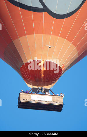 Close-up d'une orange hot air ballon en vol, avec la flamme montrant au-dessus de l'baskeet, Mareeba, Far North Queensland, Queensland, Australie, FNQ Banque D'Images