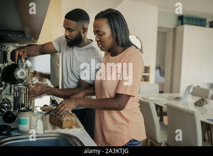 Smiling young African American couple préparer le petit-déjeuner dans la cuisine Banque D'Images