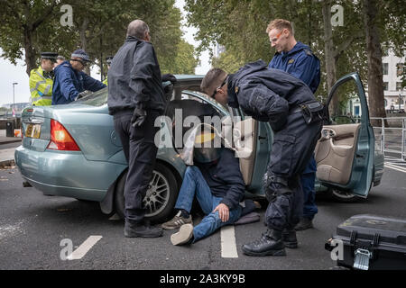 "Spécialiste" de l'équipe de dépose de protestation de l'unité de police tentent de s'affranchir d'un manifestant sur de l'intérieur d'une voiture garée à entraver Victoria Embankment qui l'extinction des manifestants ont tenté d'occuper la rébellion à partir de 6h. Les défenseurs de la commencer une nouvelle vague de protestation ce matin a entraîné un bouleversement à Londres, au Royaume-Uni. Banque D'Images