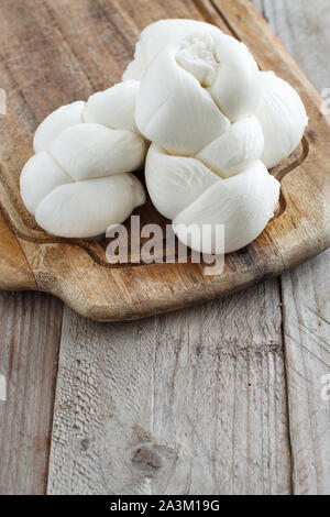 Fromage Mozzarella italienne tressé sur une planche en bois close up Banque D'Images