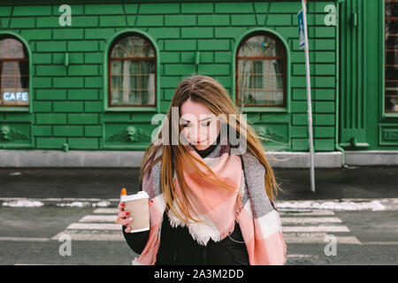 Jeune femme dans des vêtements chauds en hiver crossing city street Banque D'Images