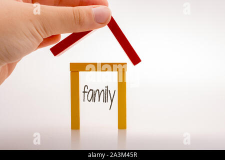 Hand holding pièces domino formant une forme de maison Banque D'Images