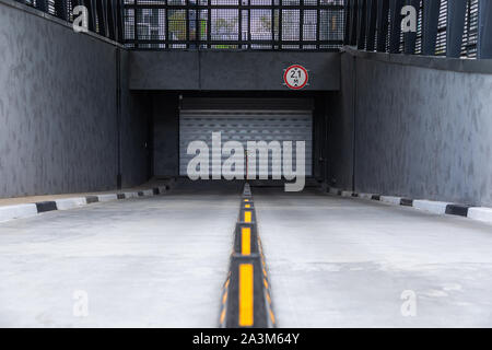 Entrée de parking souterrain avec rouleau-porte d'obturation et les diviseurs de la route Banque D'Images