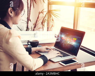 Business Woman Reading fake news ou canular sur le contenu sur Internet via ordinateur portable sur le lieu de travail Banque D'Images