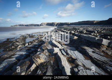 Plage de Kilve. Le Somerset. UK. Couches alternées de calcaire et de schiste créer ces étagères intertidaux et les stries dans les falaises. Banque D'Images