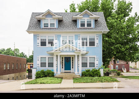 Colonial de trois étages avec parement bleu mignon sur petit terrain en zone urbaine Banque D'Images