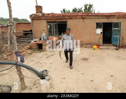 (191009) -- FUXIN, 9 octobre 2019 (Xinhua) -- Hou Gui prépare ses outils pour patrouiller dans la forêt dans le comté de Zhangwu Fuxin City, Liaoning Province du nord-est de la Chine, le 18 juillet 2019. Hou Gui, 68, est un villageois de Liujia Village d'Sihecheng Ville de Zhangwu Comté. Vivant à la limite sud de Horqin sandy land, Hou a planté plus de 200 000 arbres sur 2 400 UM (160 hectares) de terres de sable au cours des 18 dernières années. 'Lorsque j'étais enfant, le vent souffle le sable et je ne pouvais rien voir." Hou Gui a dit. Afin de protéger sa patrie, Hou Gui a commencé le boisement en 2001. Au cours des dernières années, avec Banque D'Images