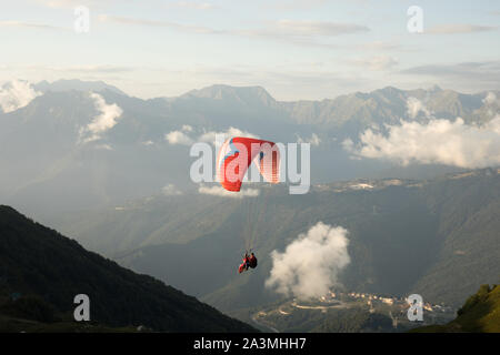 Sochi/Russie - Août 4,2019 : deux personnes dans un tandem en parapente voler dans le ciel au dessus des montagnes. Banque D'Images