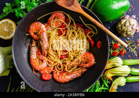 La cuisson des pâtes italiennes avec tiger gambas ou crevettes avec légumes. Concept cuisine méditerranéenne. Banque D'Images