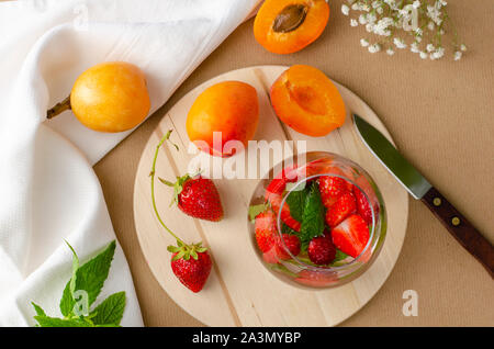 Punch aux fraises cocktail fait maison , et abricots frais loquat sur arrière-plan. Concept des boissons rafraîchissantes. Banque D'Images