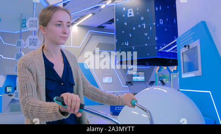 Jeune femme à l'aide d'interactive location machine simulateur Banque D'Images