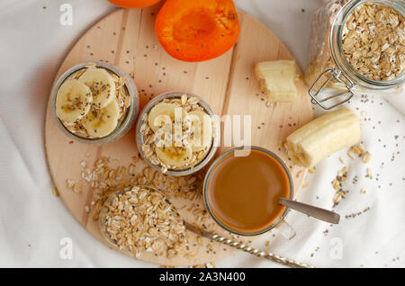 Des semences chia pudding à la banane, l'abricot frais de repas et de l'avoine sur planche de bois. Coup de frais généraux Banque D'Images