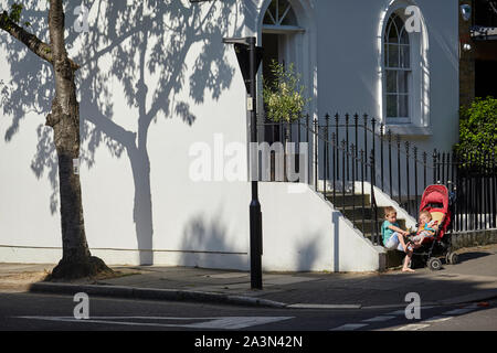 Les enfants sur les marches d'une maison à Islington, Londres. Banque D'Images