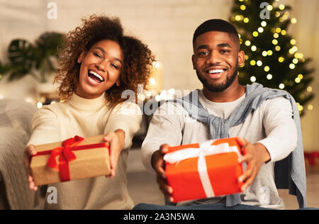 Black couple holding Christmas Gift boxes and smiling Banque D'Images