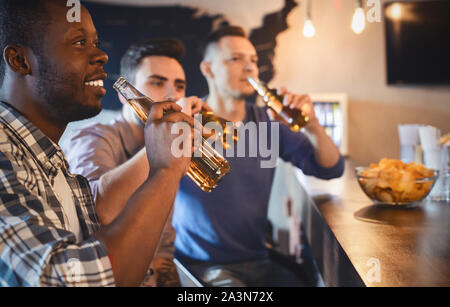 Les jeunes fans de football regarder match en pub Banque D'Images