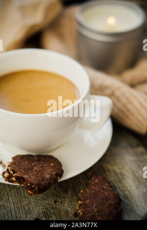 Tasse de café avec du lait et des cookies au chocolat sur couverture de laine chaude Banque D'Images