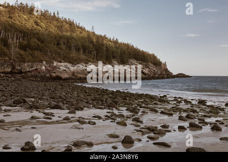 Coucher de soleil sur le littoral accidenté de la plage de sable fin lors d'une fraîche soirée d'Automne dans le parc national Acadia sur Mount Desert Island, dans le Maine. Banque D'Images