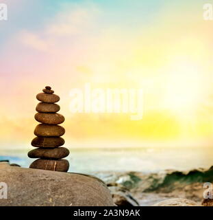 Belle pile de galets sur une plage de sable. Mer sur l'arrière-plan. Banque D'Images