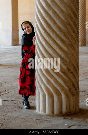 Shiraz, Iran - 2019-04-08 - femme se trouve à côté d'une colonne cannelée de mosquée Vakil. Banque D'Images